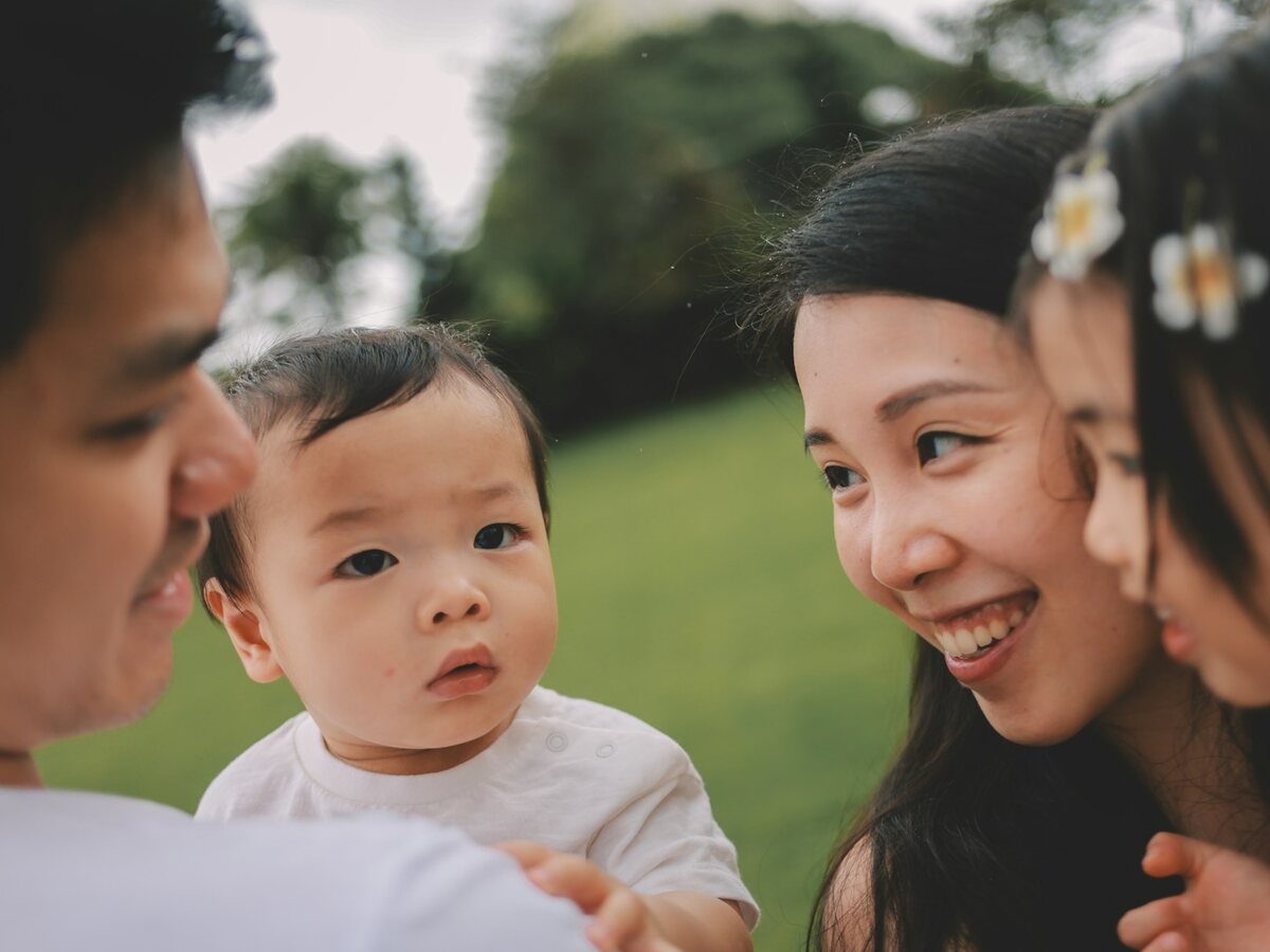 A mom and her two kids together outdoors at the park